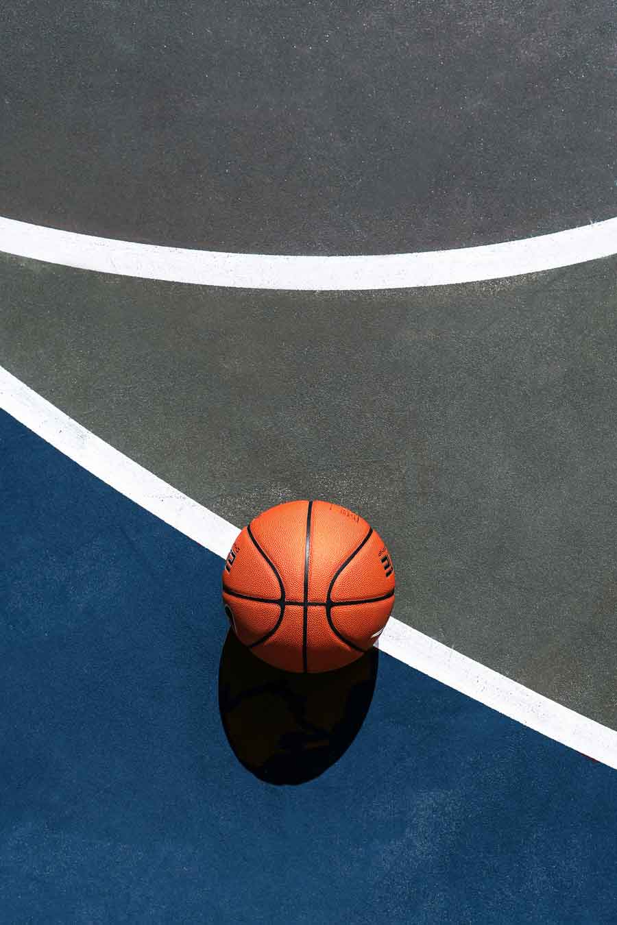 Basketboll på en basketplan. bakgrund delvis färgad i mediehusets färger